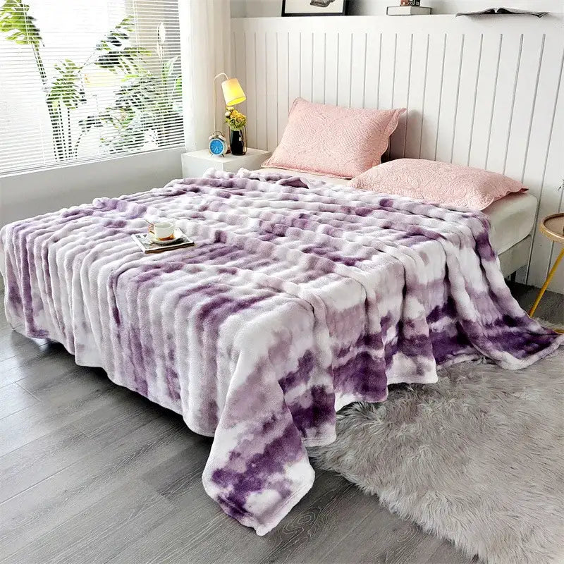 A plush tie-dye purple and white fleece throw blanket with soft fluffy texture and chunky weave for living room use