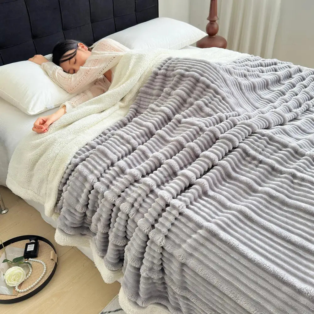 Soft gray plush blanket with ribbed fleece surface and white sherpa lining made of cozy lamb wool by decorbites
