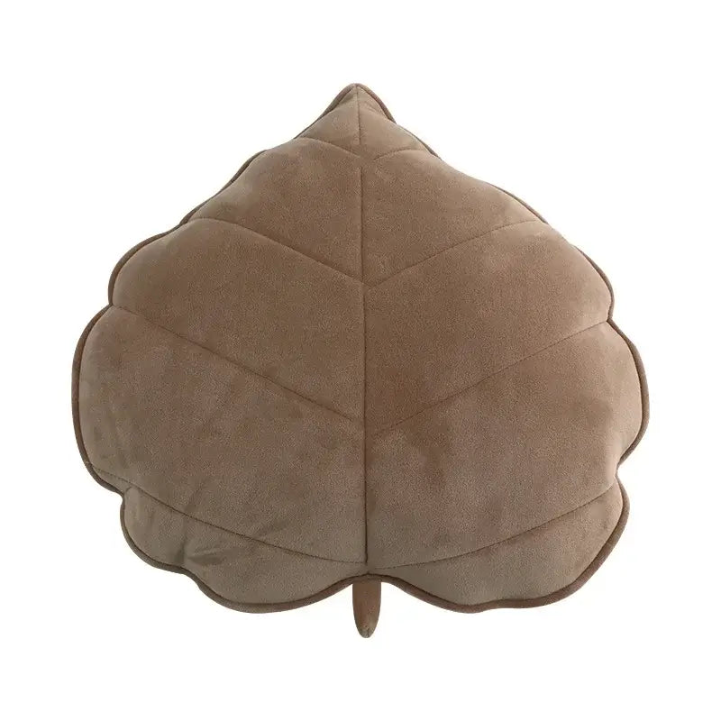 A taupe plush leaf shaped throw pillow with quilted texture and stitched veins for living room decorbites 3d leaf decor