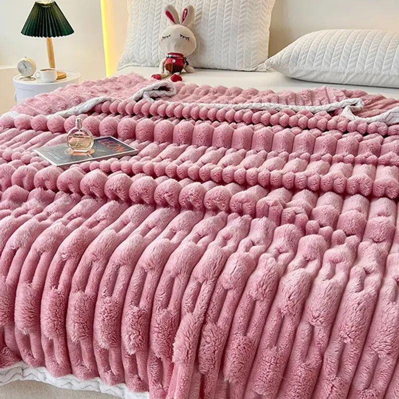 Plush pink bamboo velvet blanket with a textured chunky cable-knit pattern and white braided fringe trim for bedroom use