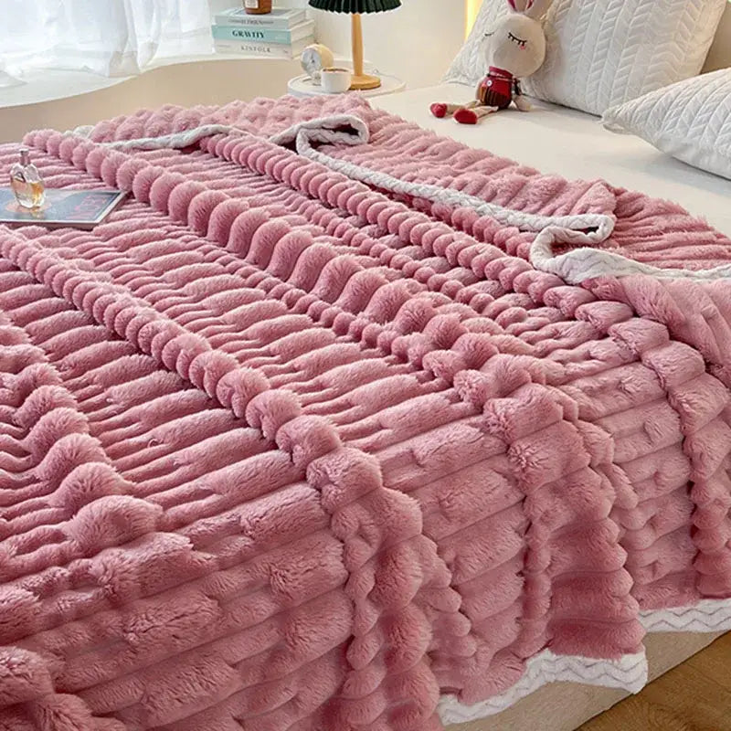 Plush pink bamboo velvet blanket with textured wavy knit pattern and white braided trim for bedroom throw