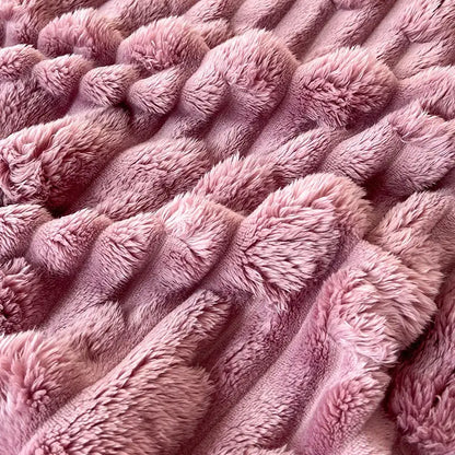 Soft pink plush bamboo velvet blanket with textured ribbed pattern and braided trim for bedroom throw