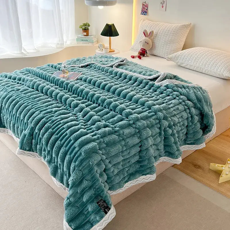 Teal plush throw blanket with textured surface and white zigzag trim made of bamboo velvet for bedroom use