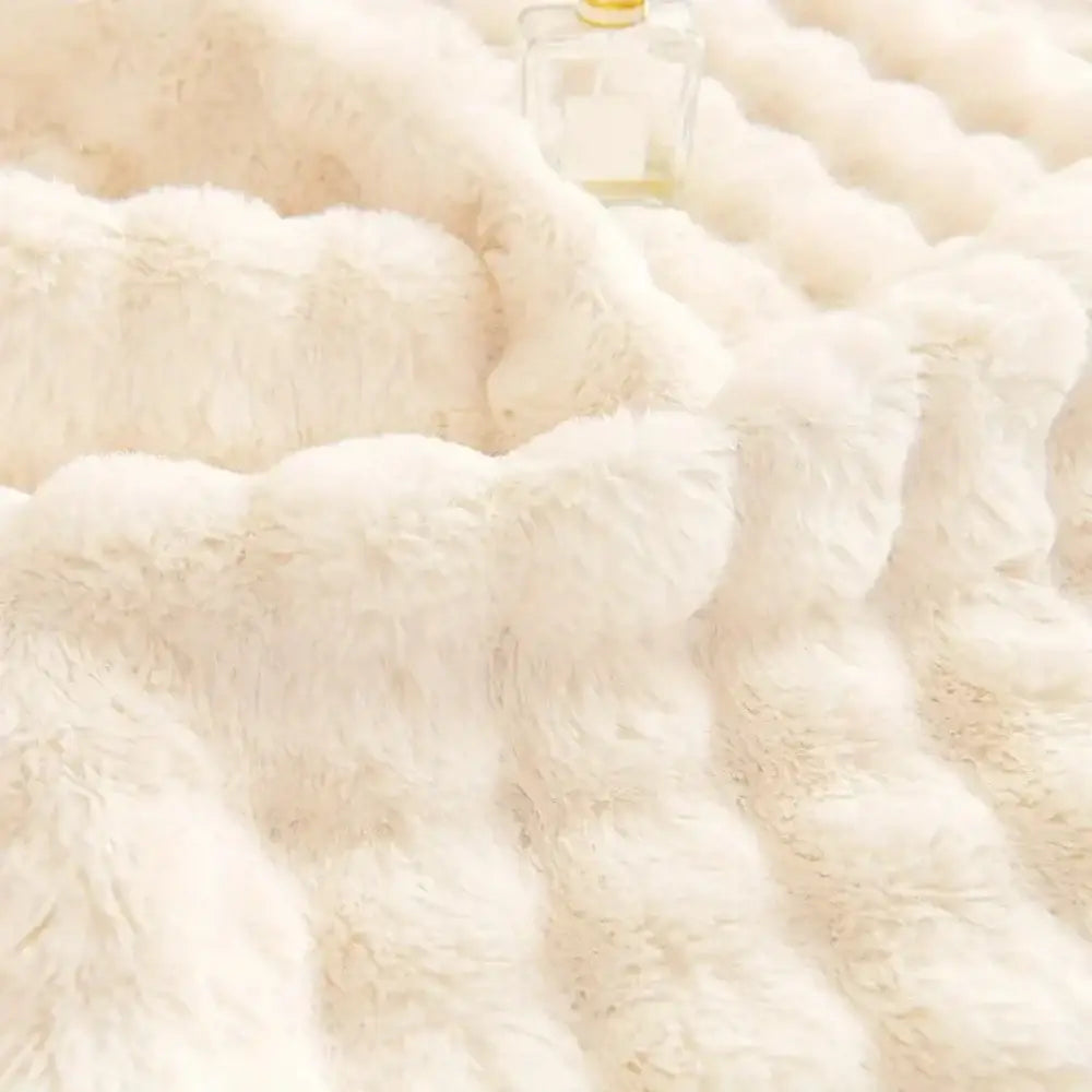 Plush quilted beige and cream rabbit fur sofa slipcover with cream-colored, soft textured faux fur and wave-like ridges