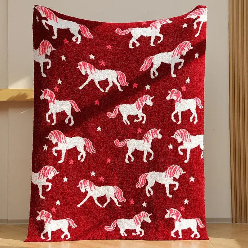 Plush red unicorn blanket featuring fleece red material with white unicorns and star patterns for bedroom use