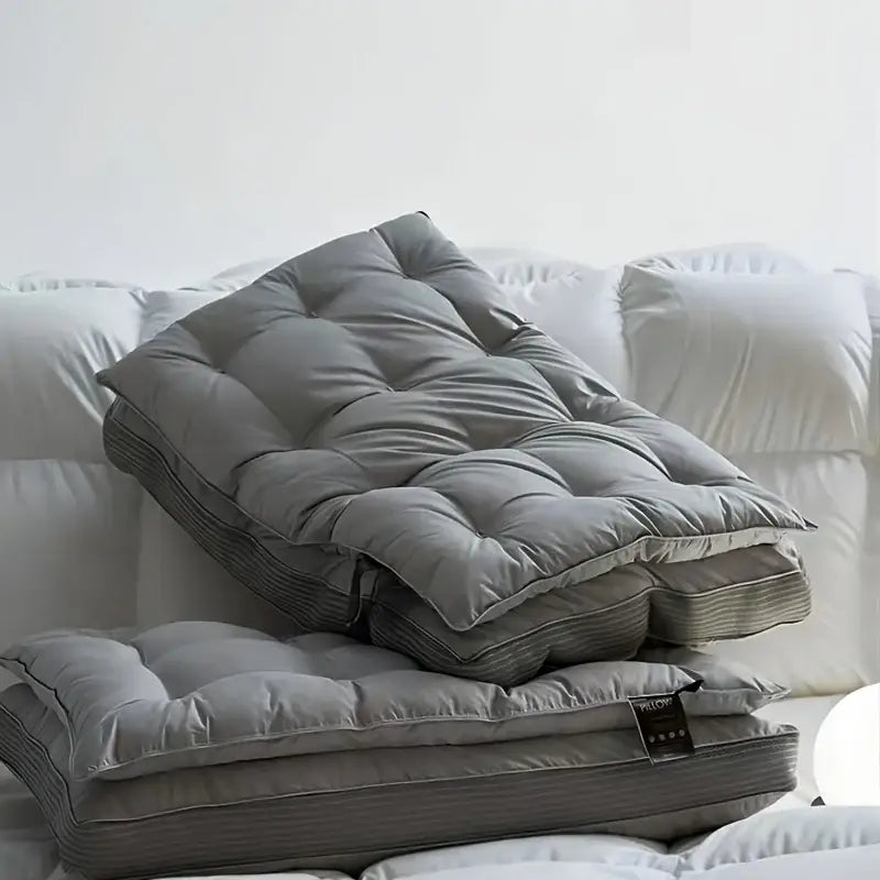 Gray quilted double layer fiber pillow topper with plush texture and subtle striped edges for neck support in bedroom