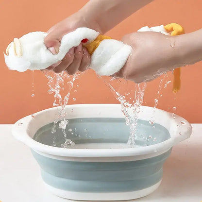 A collapsible silicone basin with a white rim and light blue body shown alongside a plush white and gray duck terry towel kitchen cleaning cloth