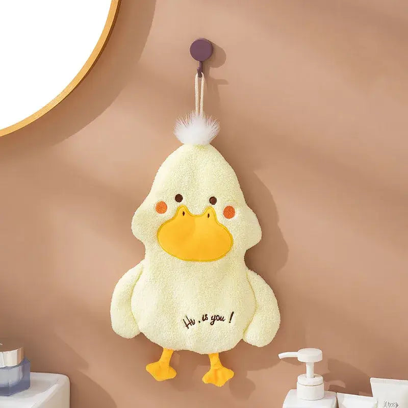 A soft pale yellow duck terry towel holder with bright orange beak and feet and a white pom-pom detail