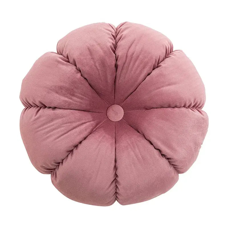 A plush rose-colored velvet flower-shaped cushion with stitched petals and button detail for home decor and decorbites 3d flowers pillows