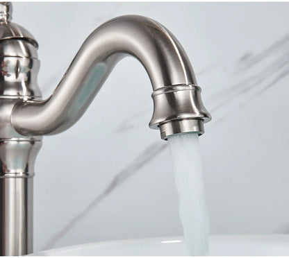 A sleek brushed stainless steel deck mounted single hole kitchen faucet with curved spout and polished finish housing material