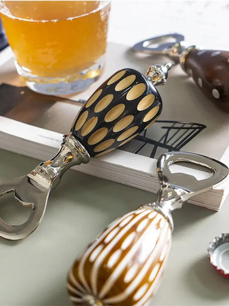 Black and gold polka-dotted ceramic beer bottle opener with shiny metallic handle enhancing drinking experience