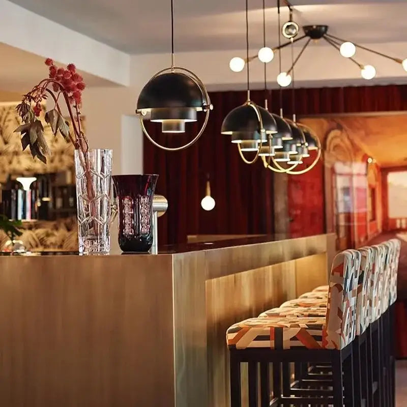 Post modern black and gold iron pendant lights with metal frames hang in an industrial dining room decorbites iron pendant lights