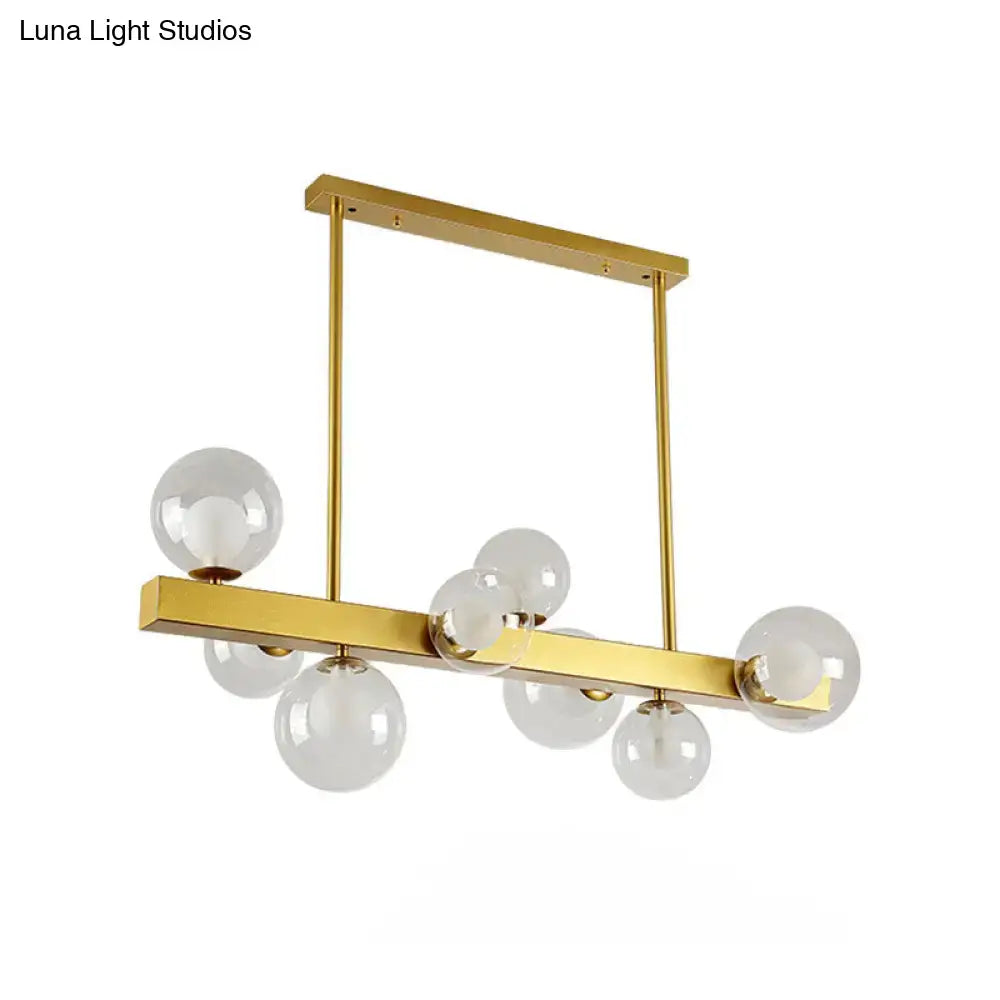 Gold-toned DecorBites™ chandelier with eight clear glass globe light bulbs in post modern design for dining room use