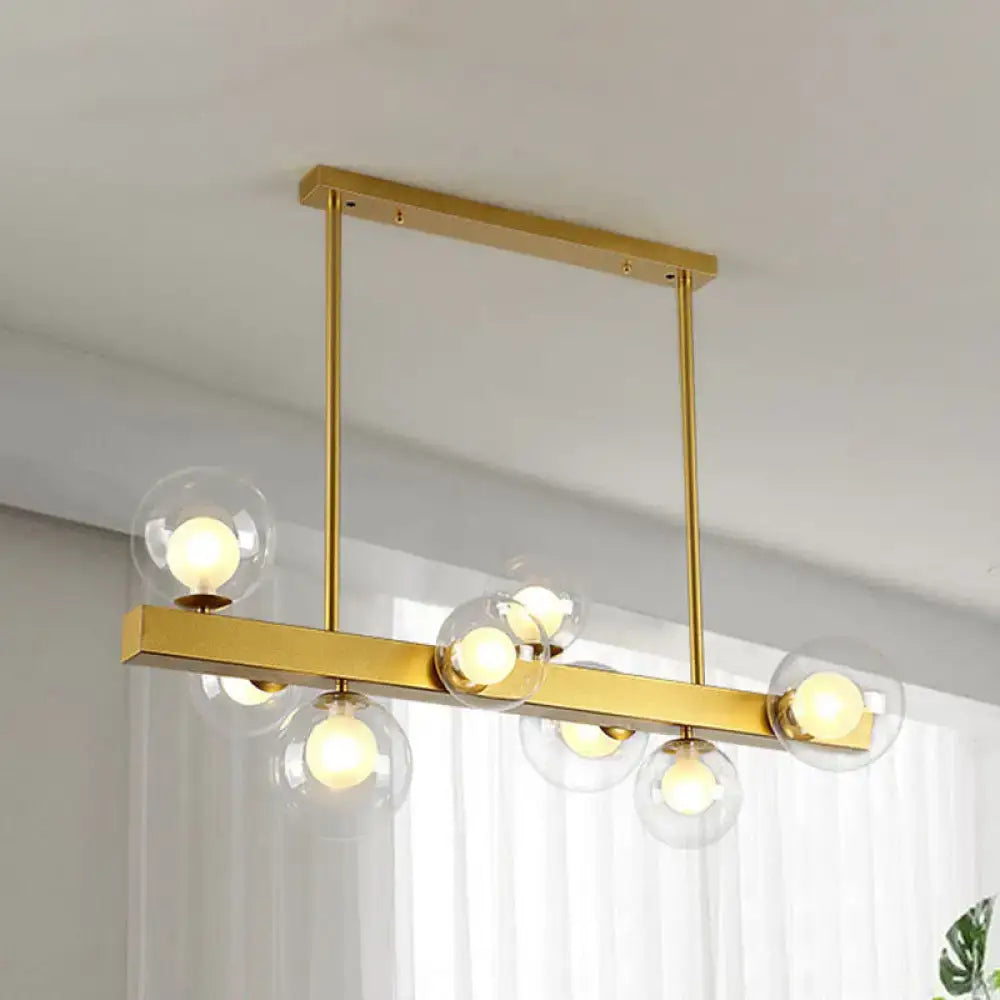 Gold-toned DecorBites™ chandelier with clear glass globe shades and exposed light bulbs for post modern dining room use
