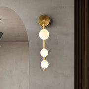 Post modern gold finish wall lamp with three frosted glass spheres aligned vertically for living room lighting