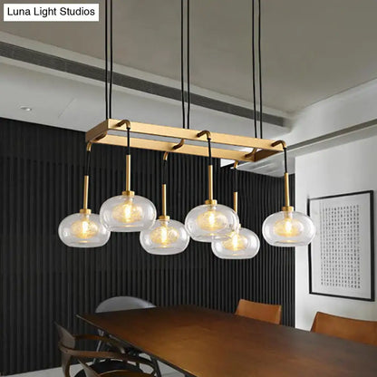Modern brass rectangular chandelier with five clear glass globe pendants from decorbites post-modern collection