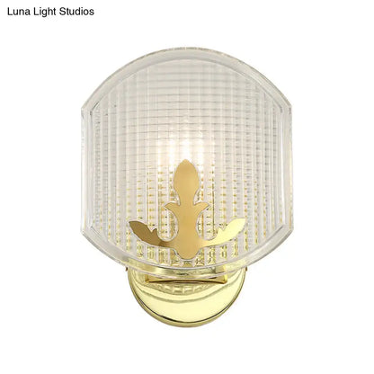 Post-modern gold wall sconce with clear lattice glass shade and ornate fleur-de-lis design for bedroom lighting