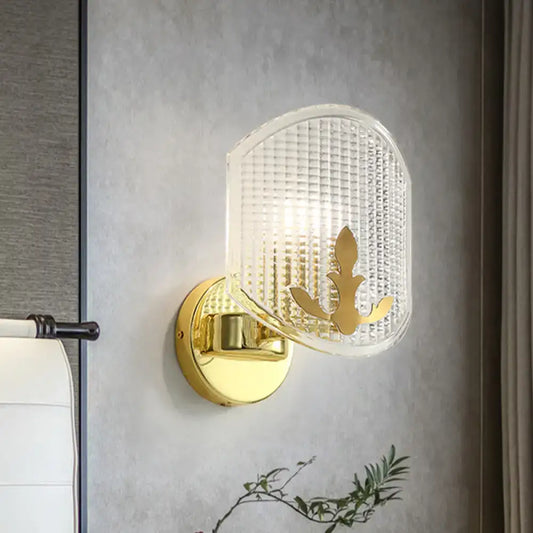 Post-modern gold wall sconce with clear lattice glass shade and ornate gold leaf design for bedroom lighting