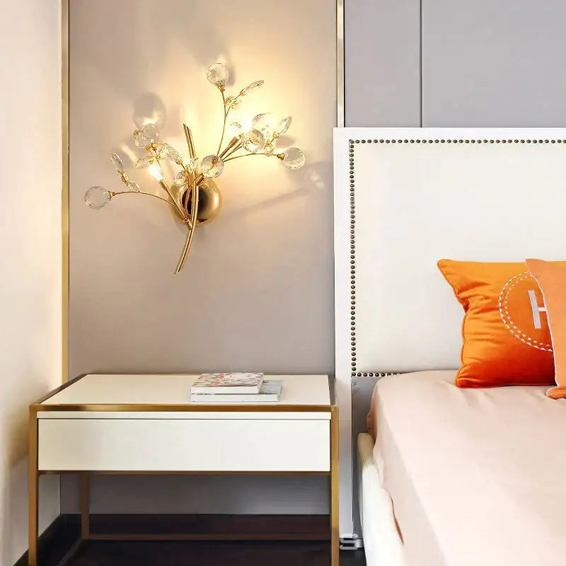 Post modern luxury gold-toned wall sconce with crystal accents in luxury branch style for bedroom lighting