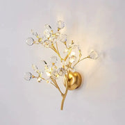 Post modern luxury gold-toned wall sconce with crystal branch and spherical accents for bedroom lighting