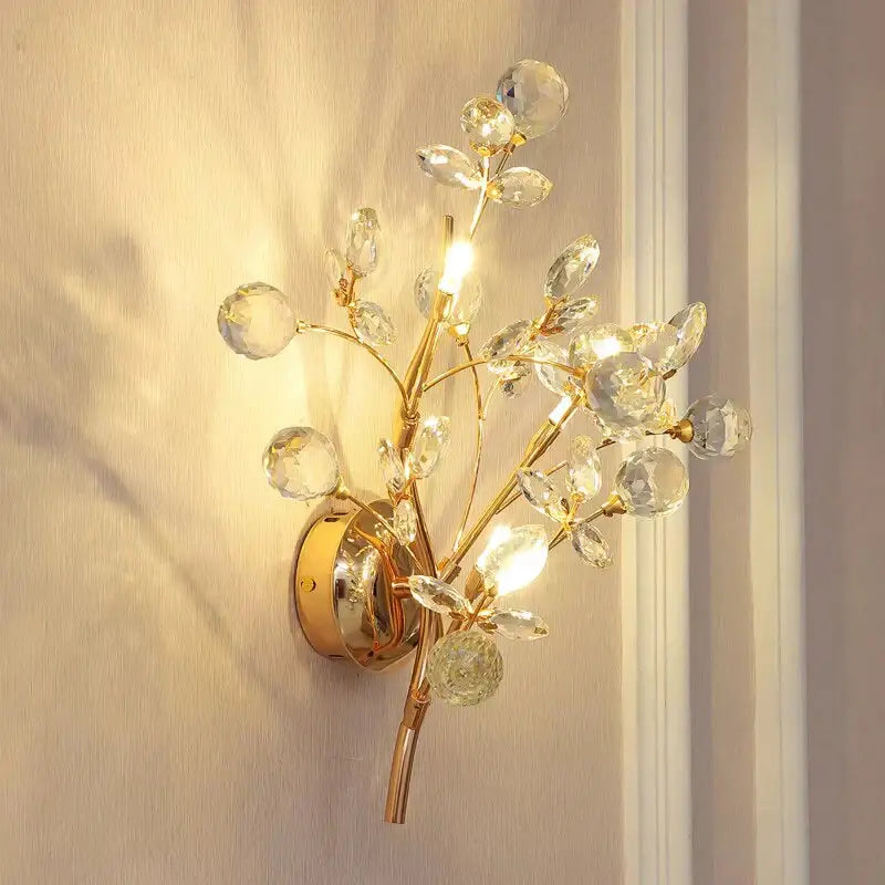 Post modern luxury gold crystal branch wall sconce with faceted clear crystals and polished brass base for bedroom use