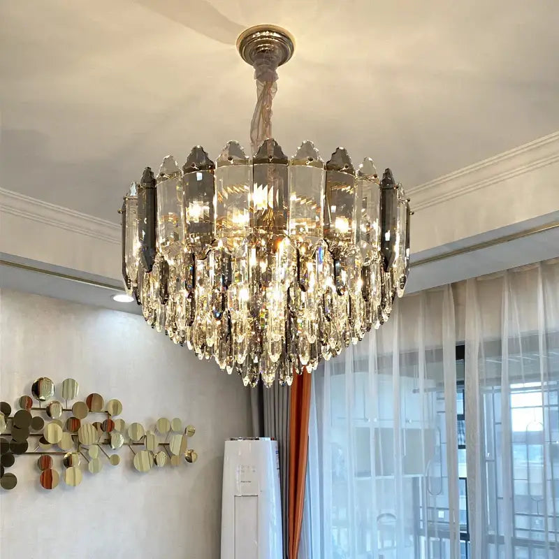 Post modern silver and brass decorbites crystal chandelier with gold frame and cascading gray and clear crystals