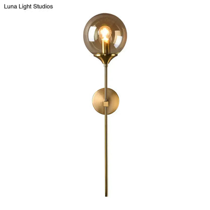 Brass-finished wall sconce with smoke grey glass globe and exposed filament e27 bulb for bedroom lighting