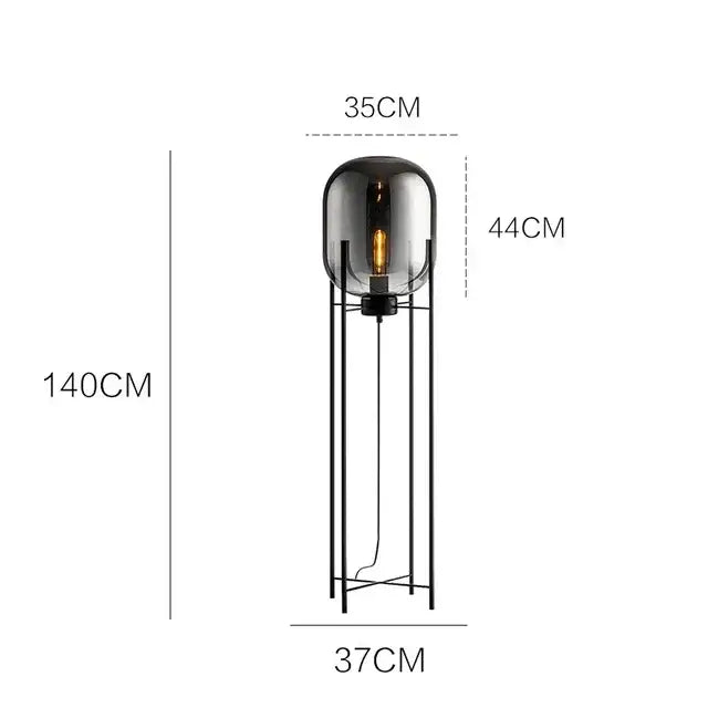 Modern floor lamp with a black metal frame and amber glass ball featuring an exposed filament bulb decorbites glass ball