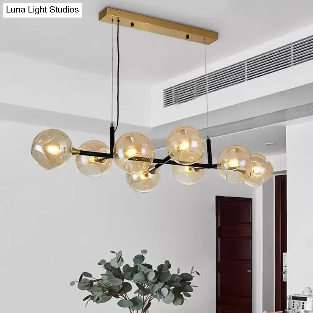 Modern brass and black metal chandelier with amber ball glass globe bulbs for island lighting with adjustable cord