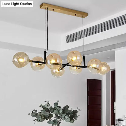 Modern brass and black metal chandelier with amber ball glass globe bulbs for island lighting with adjustable cord