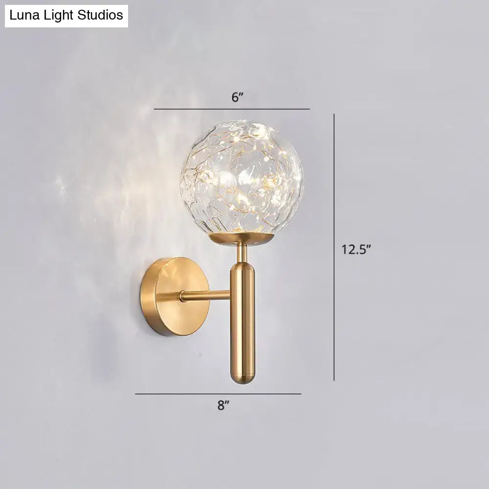 Gold-toned postmodern wall sconce with crackled prismatic glass shade and warm led lights for modern style bedroom lighting