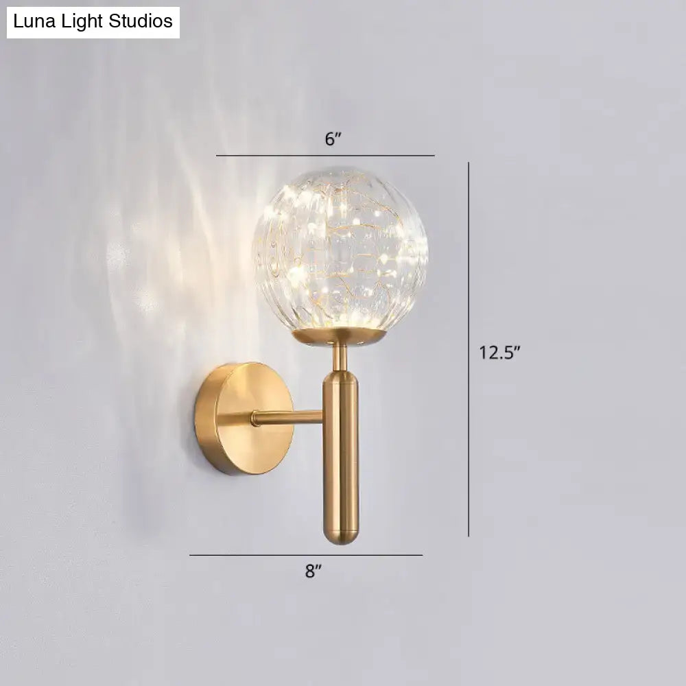 Postmodern gold-toned wall sconce with spherical glass shade and delicate internal led lights for modern style lighting