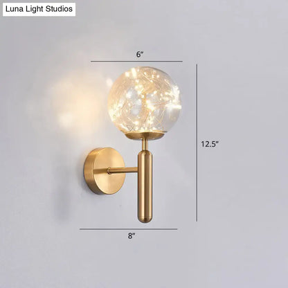 Gold-toned postmodern wall sconce with prismatic glass shade and delicate string lights for modern bedroom lighting