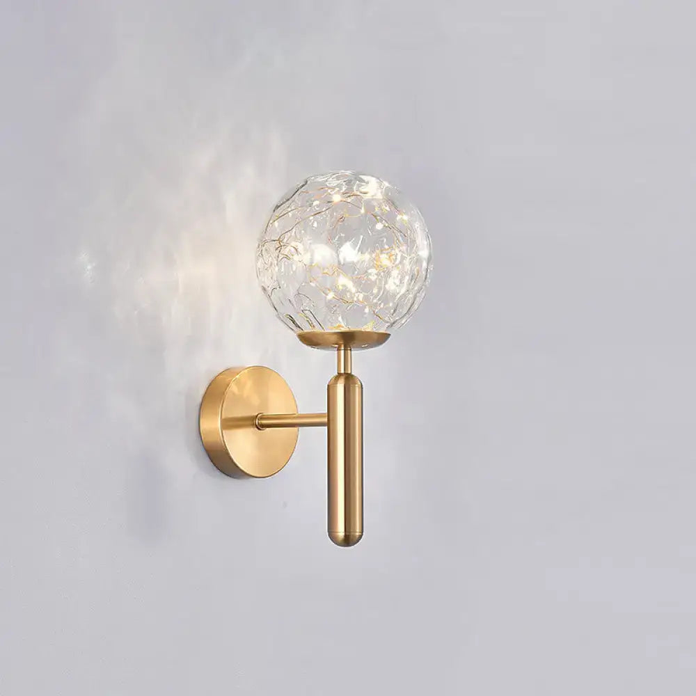 Gold-toned postmodern wall sconce with crackled prismatic glass shade for modern style bedroom lighting