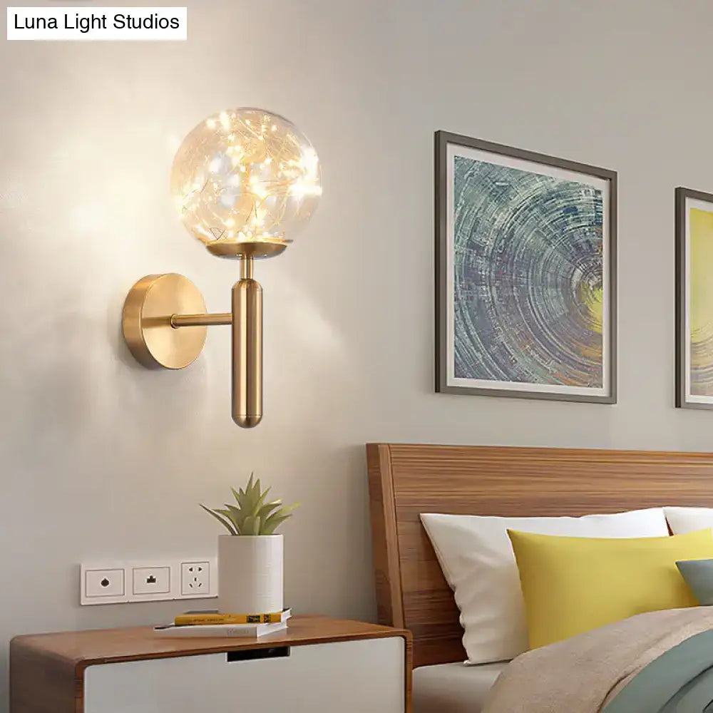 Gold-toned postmodern wall sconce with black prismatic glass shade and warm fairy lights for modern style bedroom lighting