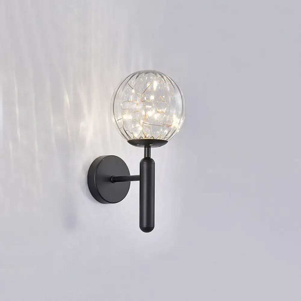 Postmodern black metal wall sconce with a prismatic glass shade and warm LED fairy lights in modern style