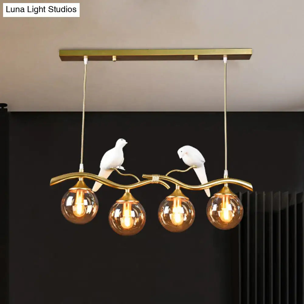 Decorbites postmodern iron pendant light in black gold with amber ball glass shade and white ceramic bird accents