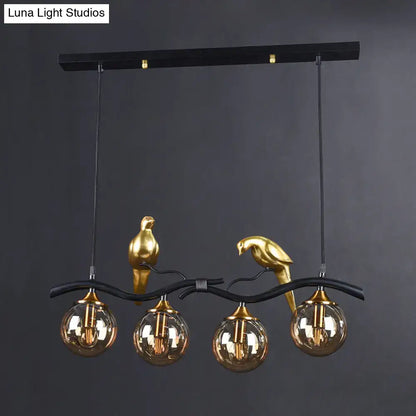 Black metal pendant light with gold bird sculptures and amber ball glass shades by DecorBites postmodern design