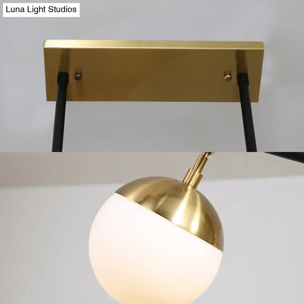 Postmodern black and gold island ceiling light with gold-finished spherical pendant and matte white glass globe