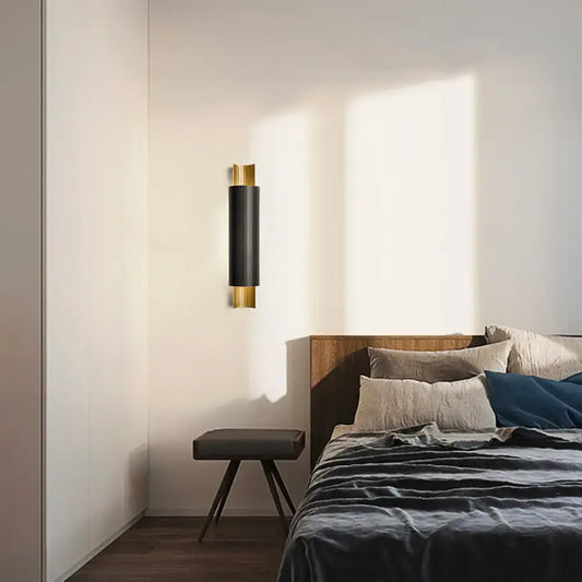 Postmodern black and gold pipe shaped led wall mount with sleek cylindrical body and polished accents for bedroom lighting