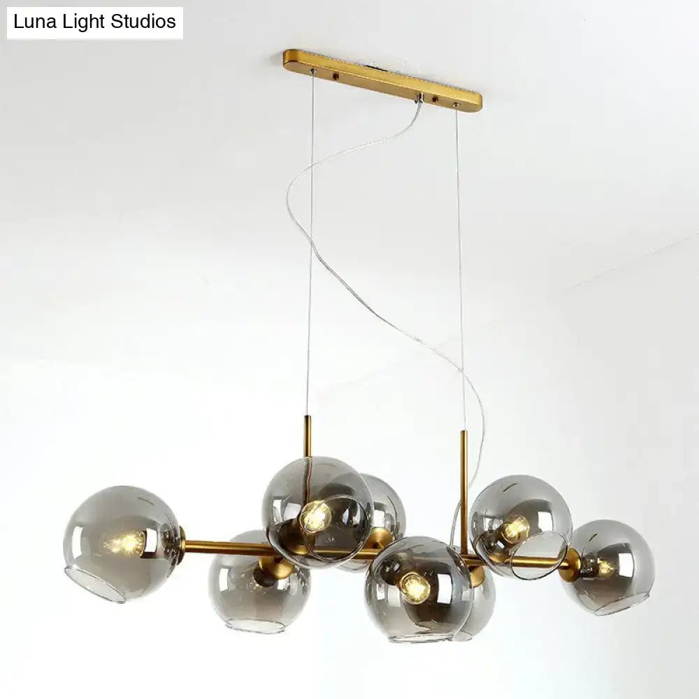 Modern brass and smoke grey clear smoke glass globe pendant light fixture with minimalist design for dining room chandelier