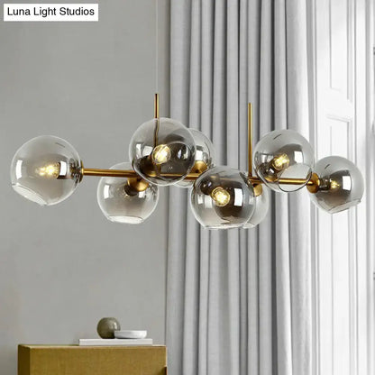 Postmodern black metal 8 head chandelier with modern brass and clear smoke grey glass globe shades for dining room