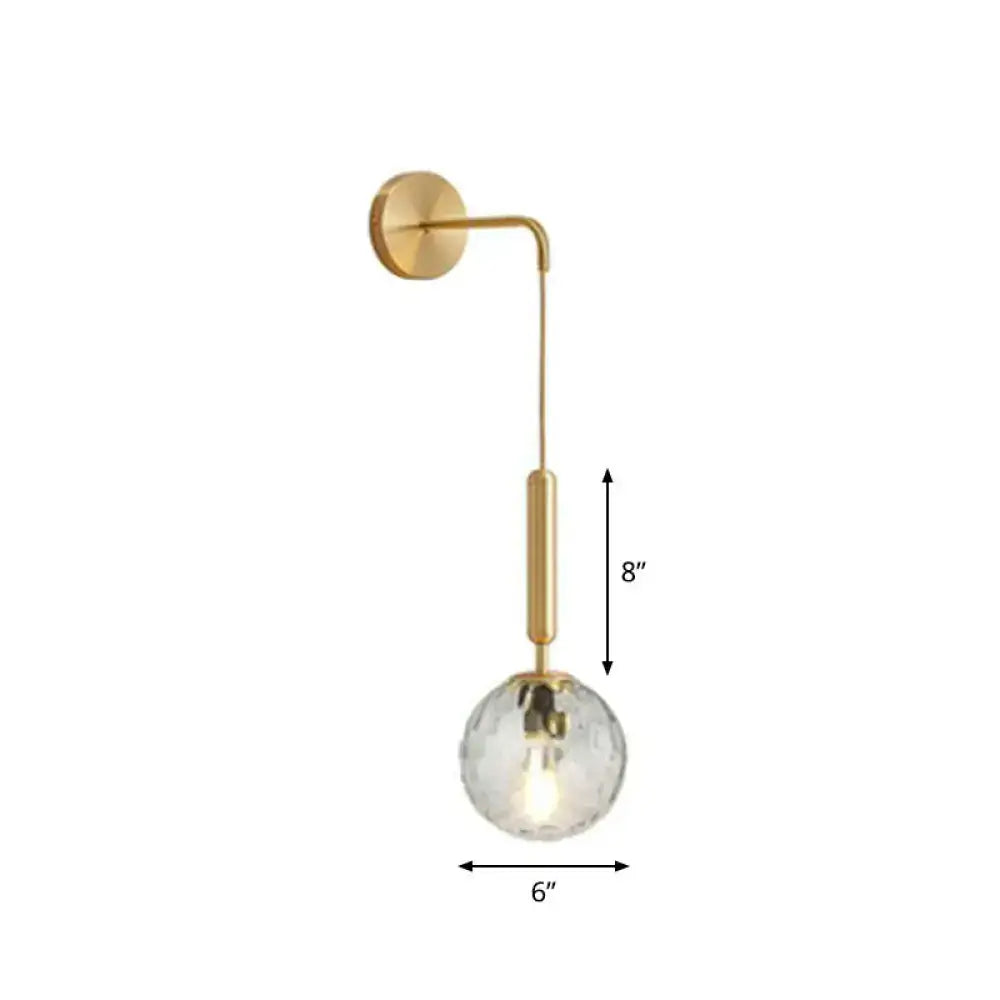 Gold-toned wall lamp with faceted crystal globe shade and frosted glass globe for bedroom lighting