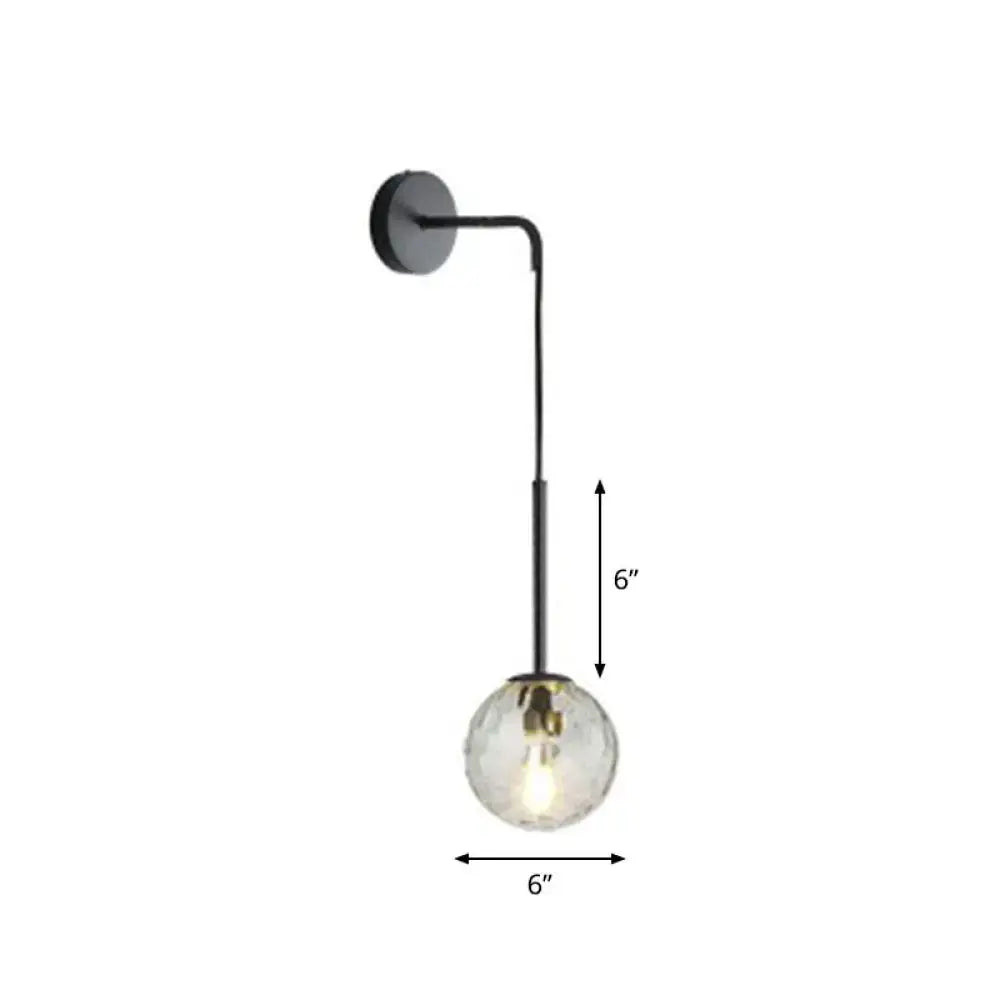 A sleek black metal wall lamp with a 6-inch clear glass globe bulb for modern bedroom lighting