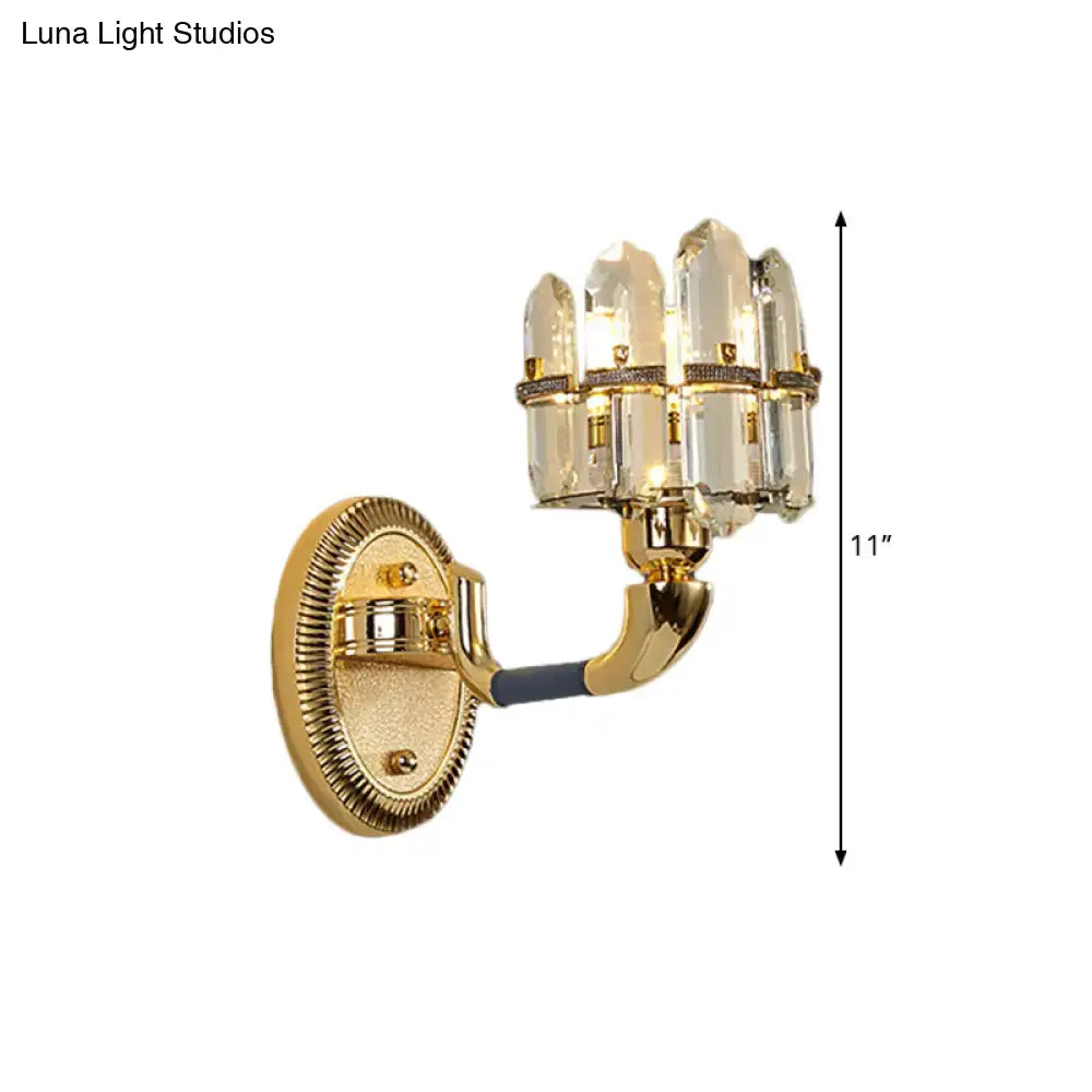 Gold-finished wall mount lamp with five clear crystal prisms in a fan-like cluster for bedroom sconce lighting