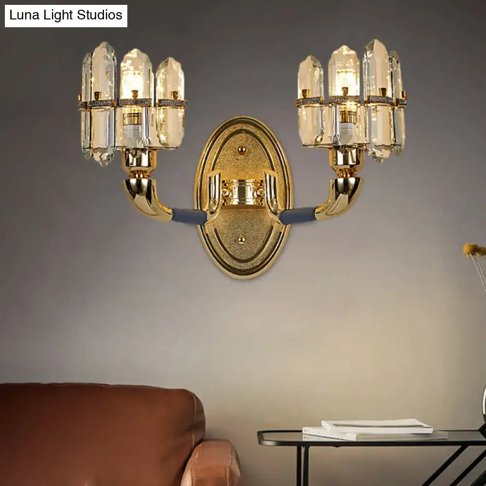 Gold-toned postmodern wall mount lamp with two arms holding three faceted blue and gold crystal shades each