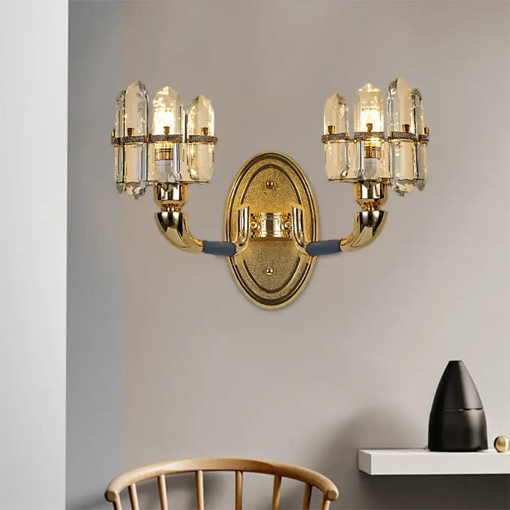 Gold-toned postmodern wall mount lamp with two arms and clear crystal glass shades for bedroom use