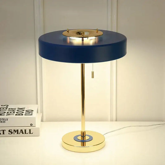 Postmodern blue and gold led bedside table lamp with a gold-toned base and central pull chain decorbites led bedside