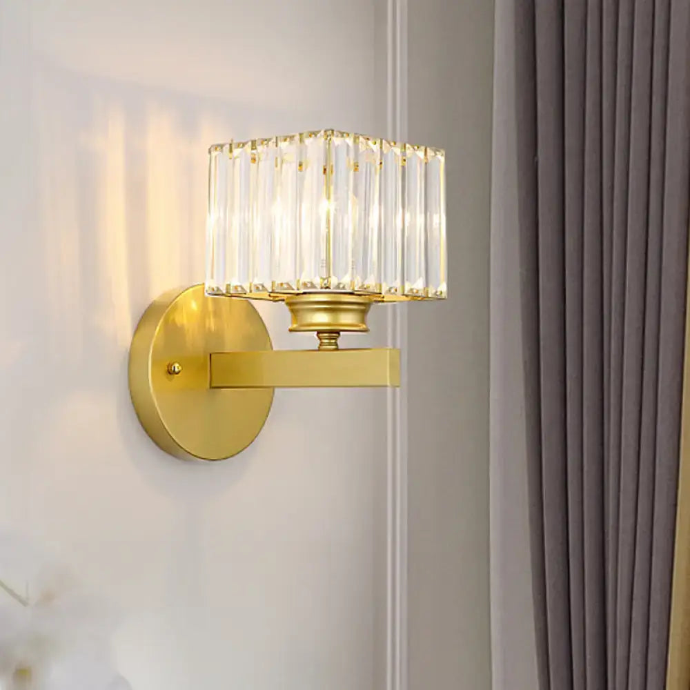 Gold-finished brass black wall sconce with rectangular crystal block shade featuring vertical glass rods for bedroom use