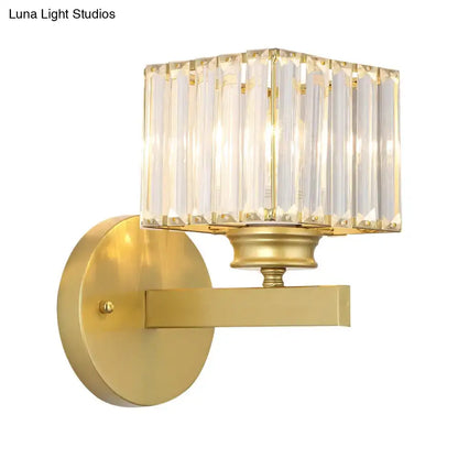Postmodern gold-finished wall sconce with brass black base and rectangular crystal block shade for bedroom lighting